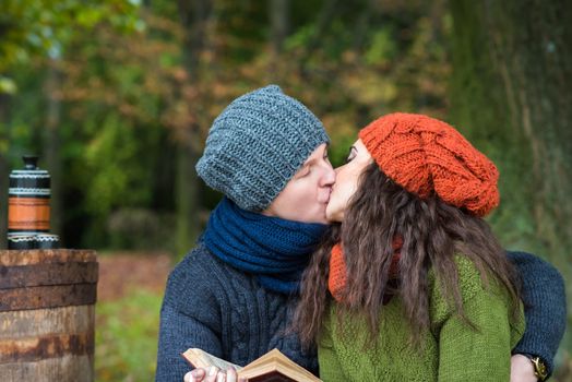 loving couple reads a book in the autumn garden