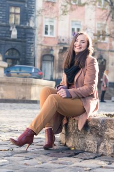 pretty girl sits on a rock in the city in the morning