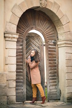 beautiful girl near old wooden gate in the city