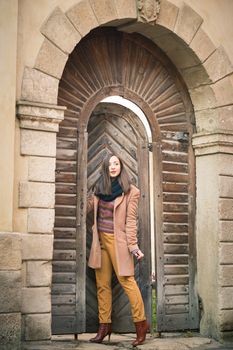 beautiful girl near old wooden gate in the city