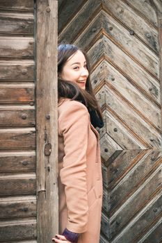 beautiful girl near old wooden gate in the city