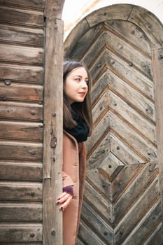 beautiful girl near old wooden gate in the city