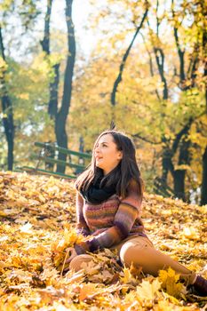 beautiful girl in autumn Park keeps yellow leaves
