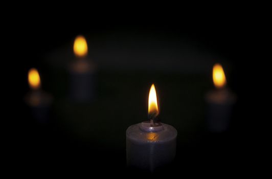 burning candles, dark background, close up on the flame