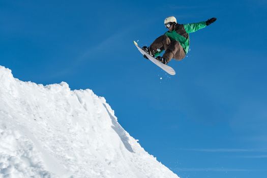 Snowboarder executing a radical jump against blue sky.