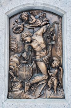 Bronze relief of San Sebastian pierced by arrows