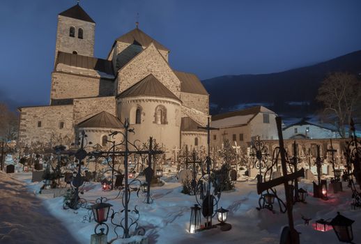 cemetery at night, close up to the crosses, church in the background, it becomes morning, snow on the ground, tombs covered with snow