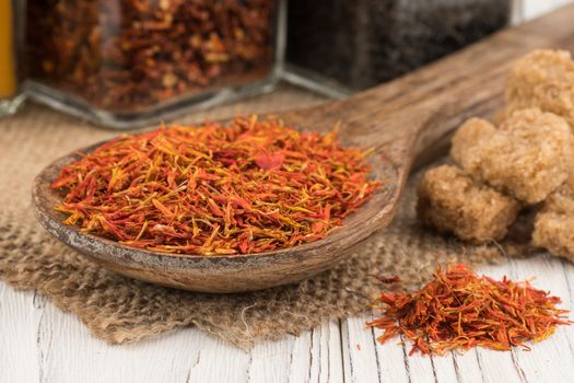 Saffron in a wooden spoon and an old white wooden table. Selective focus. 