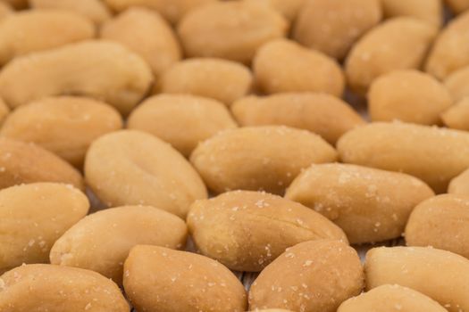 Salted peanuts on white old wooden table. Selective focus.