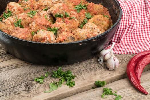 meat balls with herbs in pan on wooden rustic background. Selective focus.