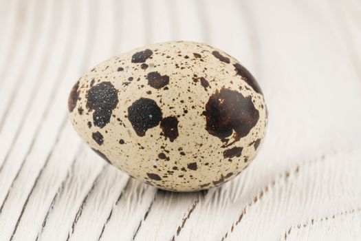 Quail egg on old white wooden table. Selective focus.