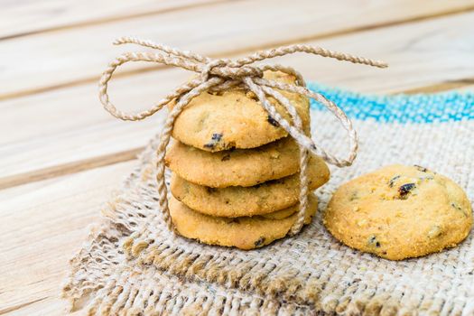 Tasty cookies with chocolate chops against wooden table