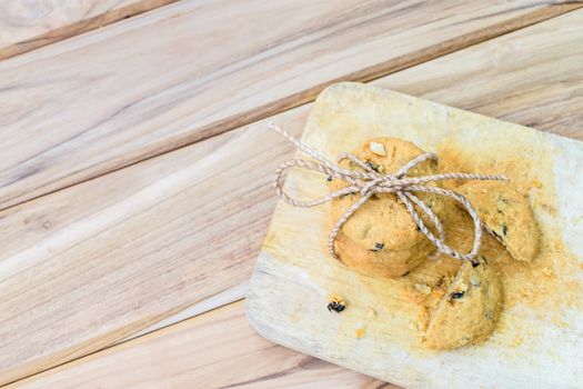 Tasty cookies with chocolate chops against wooden table