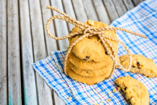 Tasty cookies with chocolate chops against wooden table