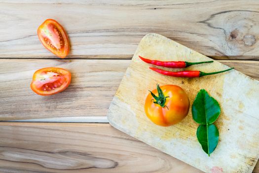 Tomatoes on chopping board with wooden