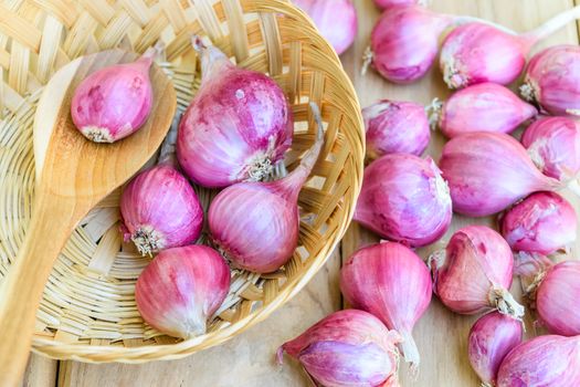 Shallot on wooden spoon and bamboo basket