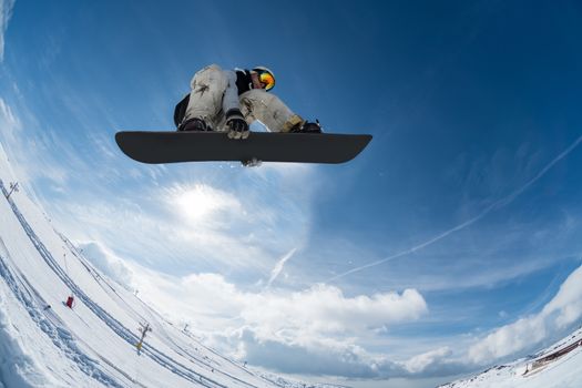 Snowboarder executing a radical jump against blue sky.