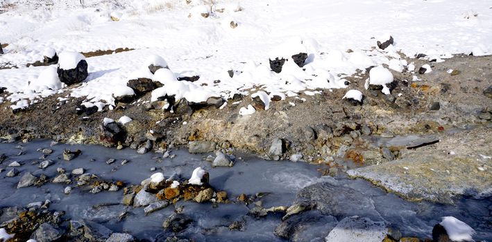 Closeup snow stone and stream in the mist Noboribetsu onsen snow winter national park in Jigokudani, Hokkaido, Japan