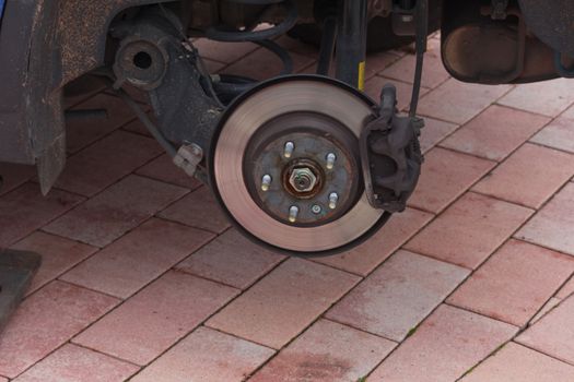 Disk brake on a car here Mechanic at the car brake repair in a car service workshop
