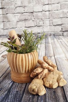 Ginger, turmeric and herbs on a wooden board