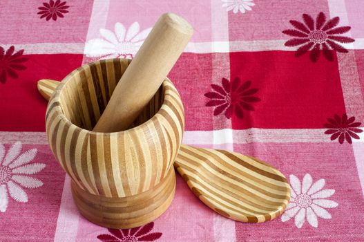 A mortar and a spoon with bamboo wood