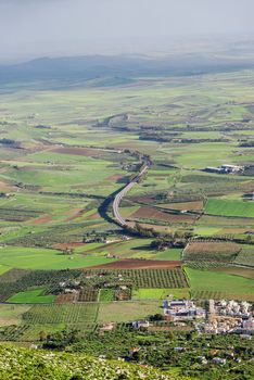 Aerial view of agricultural fields, small city, highway on Sicily, Italy