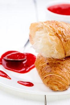 Close up strawberry jam, croissant and spoon