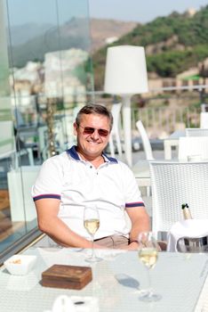 Middle aged men enjoying life and drinking champagne vine at restaurant