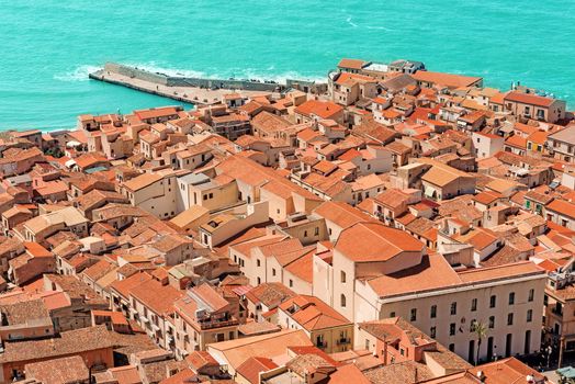 View on old red roofs and famous medieval cathedral in Cefalu city. SIcily island, Italy