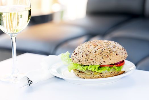 Restaurant burger with white wine on table