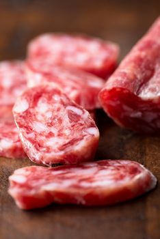 Spanish salami on wooden background close up