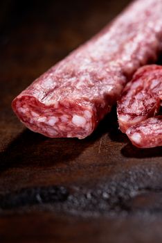 Spanish salami on wooden background close up