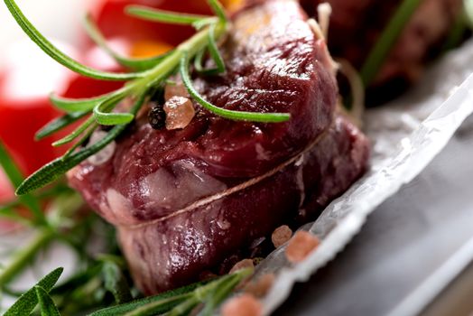 Raw beef steak with peppercorns and herbs