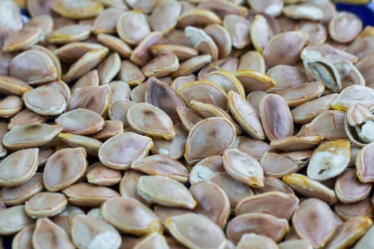 Close-up food background of dry fried yellow white pumkin seeds nuts