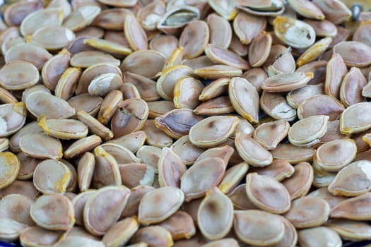Close-up food background of dry fried yellow white pumkin seeds nuts