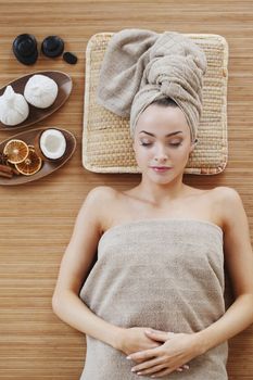 Beautiful young woman relaxing in spa salon