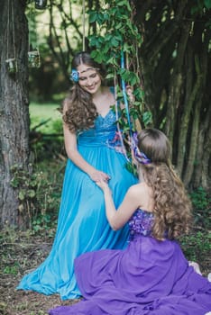 two adult sisters, twins in the summer garden