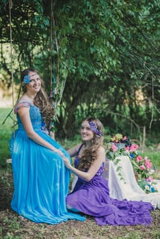 two adult sisters, twins in the summer garden