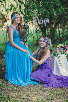 two adult sisters, twins in the summer garden