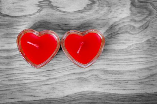 Red hearts sign from candle in glass on old wood, Valentine's background. 