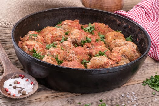 meat balls with herbs in pan on wooden rustic background. Selective focus.