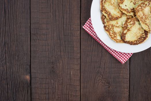 Fritters of zucchini on the old wooden table. Top view.