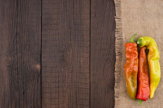 Hot peppers on old wooden table. Top view.