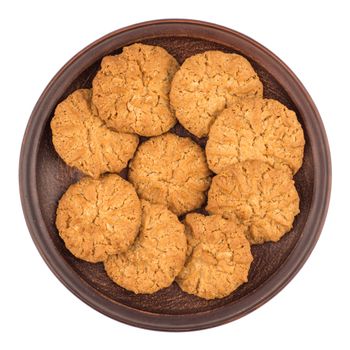 Oatmeal cookies in a brown plate. Isolated on white background. Top view.