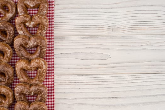 Gingerbread heart cookies on a wooden white background. Top view.