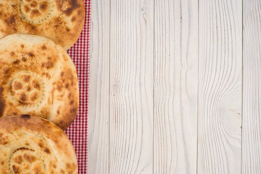 Uzbek bread on old white wooden table. Top view.