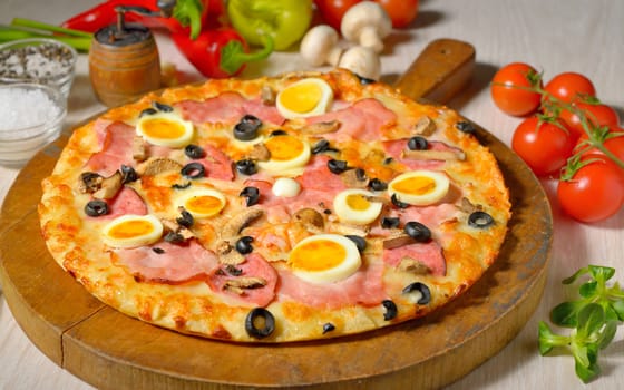 Pizza and ingredients on old wooden board