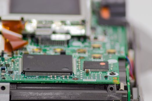 Fragment of electronic device with two chips and other electronic components in foreground closeup
