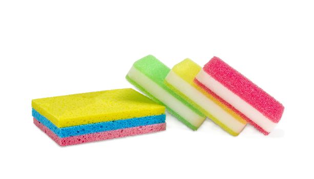 Several various synthetic cleaning sponges different colors, some of which are layered, on a light background
