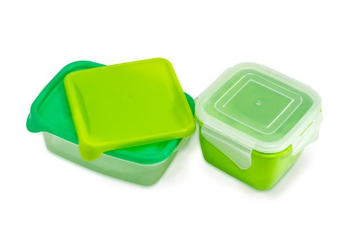 Two different green reusable plastic food storage containers with covers for home use on a light background
